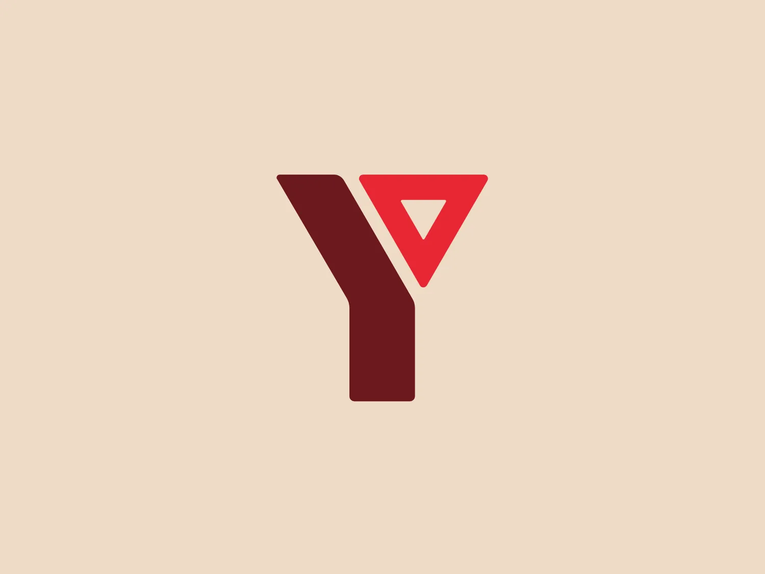 The logo for YMCA Langues showcases a modern, minimalist design with a bold maroon-hued geometry. It presents a stylized letter "Y" with one arm ending in a sharp point and the other transitioning into a cut-through triangle pointing downward, creating a dynamic visual effect. The use of negative space within the triangle adds depth and sophistication to the simple color scheme. The overall design is crisp, with clean lines suggesting a contemporary and professional brand identity.
